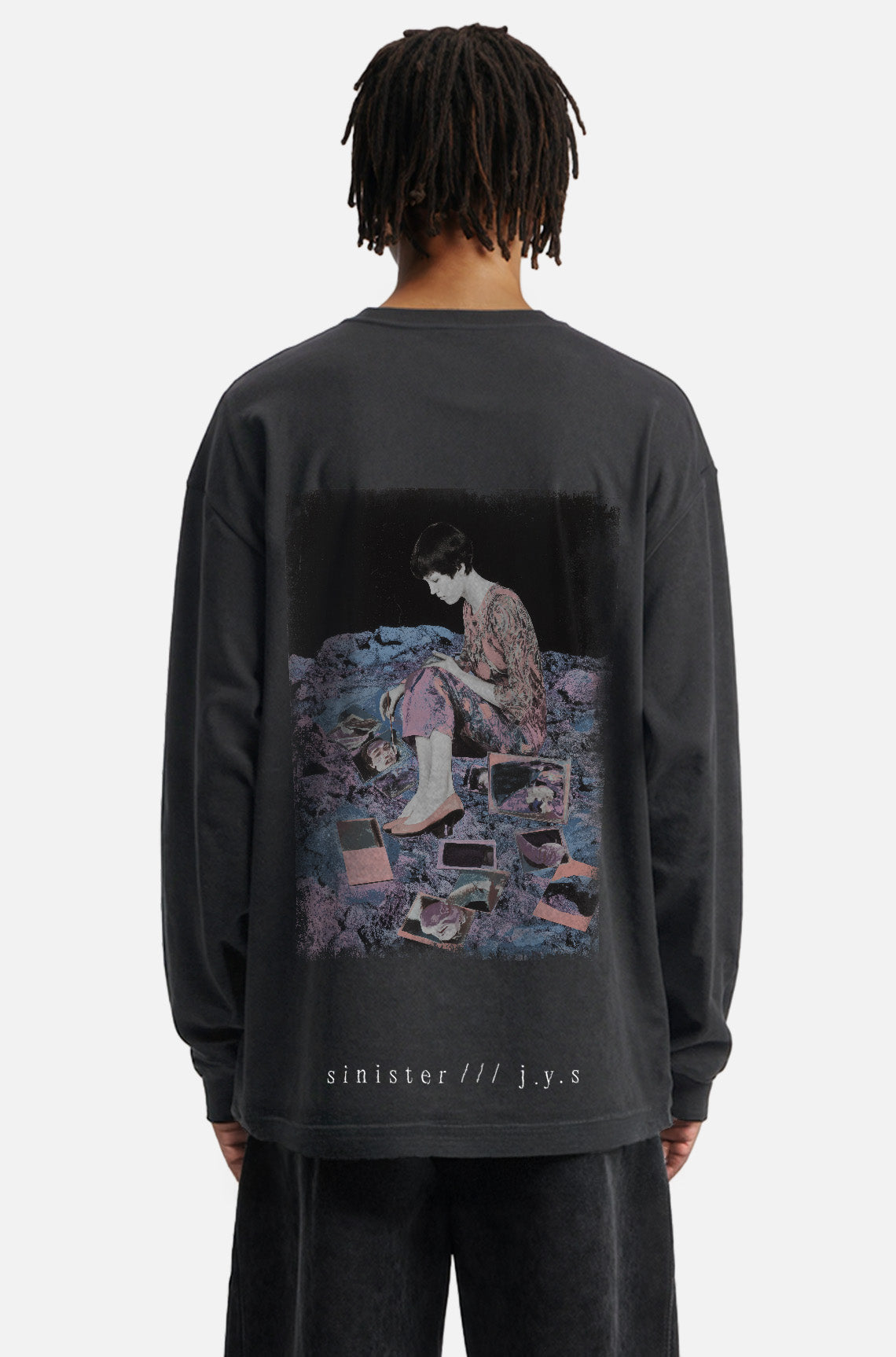 Person wearing a black long-sleeve shirt with a graphic design on the back, standing against a white background.